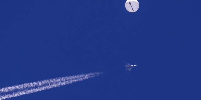 The Chinese spy balloon drifts above the Atlantic Ocean just off the coast of South Carolina with a fighter jet and its contrail seen below it on Saturday, Feb. 4.