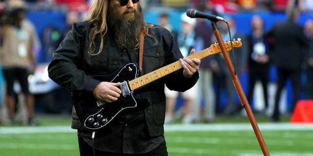 Chris Stapelton strummed a black electric guitar as he sang the national anthem Sunday.