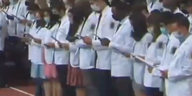 Columbia University Vagelos College of Physicians and Surgeons Class of 2025 chants a revised Hippocratic Oath focusing on "oppression" and "unconscious bias" during a ceremony in August 2021.