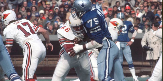Jethro Pugh #75 of the Dallas Cowboys rushes up against Conrad Dobler #66 of the St. Louis Cardinals during an NFL football game December 3, 1972 at Busch Stadium in St. Louis, Missouri. Pugh played for the Cowboys from 1965-78.