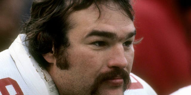 Conrad Dobler #66 de los St. Louis Cardinals observa la acción desde el banquillo durante un partido de fútbol americano de la NFL alrededor de 1977. Dobler jugó para los Cardinals de 1972 a 1977.