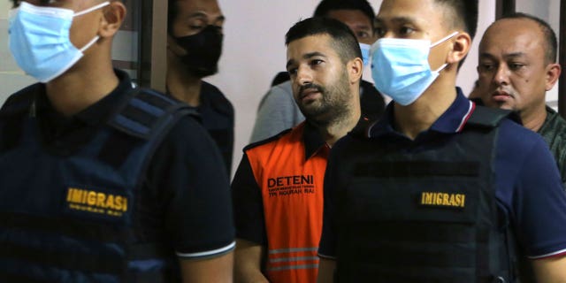 Immigration officers escorted Australian fugitive Antonio Strangio, center, to a press conference in Nusa Dua, Bali, Indonesia, on Feb. 19, 2023.