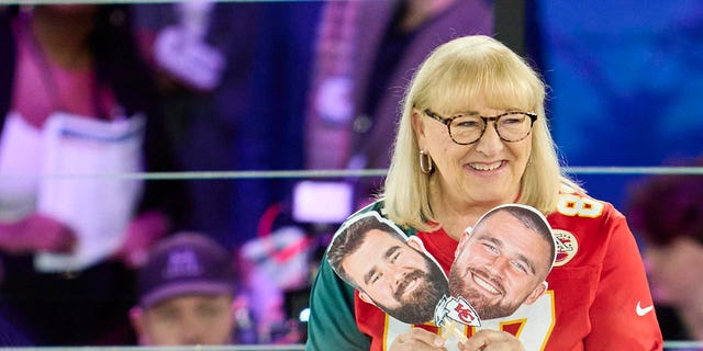Donna Kelce holds up photos of sons Jason Kelce of the Philadelphia Eagles and Travis Kelce of the Kansas City Chiefs at Footprint Center Feb. 6, 2023, in Phoenix, Ariz.