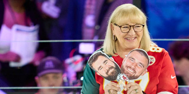 Donna Kelce holds up photos of her sons, Jason Kelce, #62 of the Philadelphia Eagles, and Travis Kelce, #87 of the Kansas City Chiefs, at Footprint Center on February 6, 2023, in Phoenix, Arizona.