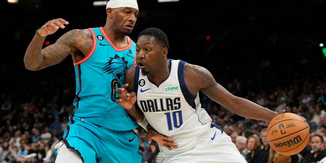 El alero de los Dallas Mavericks, Dorian Finney-Smith, No. 10, impulsa al alero de los Phoenix Suns, Torrey Craig, No. 0, en la segunda mitad en el Footprint Center en Phoenix el 26 de enero de 2023.