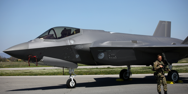 A Dutch soldier stands guard near a Royal Netherlands Air Force F-35 at Graf Ignatievo Air Base in Bulgaria on April 14, 2022.