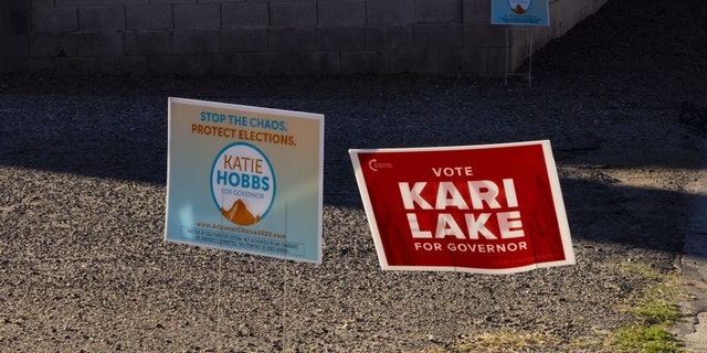 Campaign signs for gubernatorial candidates Katie Hobbs and Kari Lake outside a polling location in Tucson, Arizona, on Nov. 8, 2022.