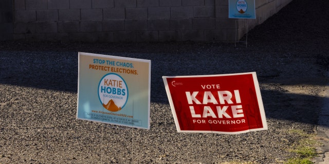 Campaign signs for gubernatorial candidates Katie Hobbs and Kari Lake outside a polling location in Tucson, Arizona, on Nov. 8, 2022.