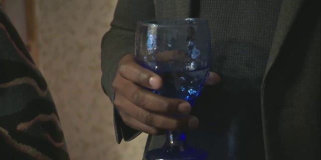 EPA Administrator Michael Regan holds a glass of tap water inside a woman's East Palestine, Ohio, home, Tuesday, Feb. 21, 2023.