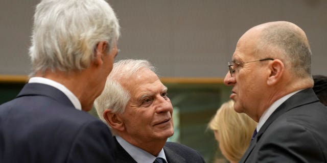 European Union foreign policy chief Josep Borrell, center, speaks with Poland's Foreign Minister Zbigniew Rau, right, and Portugal's Foreign Minister Joao Gomes Cravinho, left, during a meeting of EU foreign ministers at the European Council building in Brussels on Feb. 20, 2023.