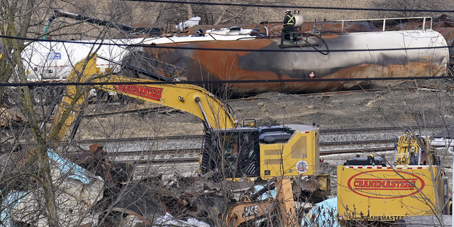 Workers are seen on Tuesday, February.  February 21 while cleaning derailed train cars in East Palestine, Ohio, after the tragedy.  3 Norfolk Southern freight train derailments. 