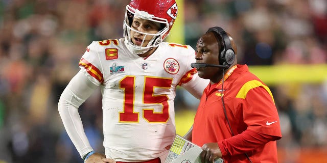 Patrick Mahomes #15, of the Kansas City Chiefs, talks with offensive coordinator Eric Bieniemy during the fourth quarter against the Philadelphia Eagles in Super Bowl LVII at State Farm Stadium on February 12, 2023, in Glendale, Arizona.