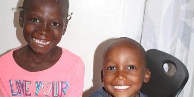 Photo of two adopted Haitian children, 5-year-old Peterson and 6-year-old Gina, waiting for passports to enter the United States