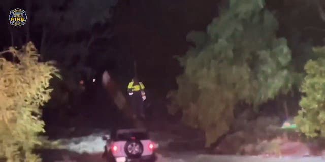 The Ventura County Fire Department conducts a daring aerial rescue of a driver trapped successful rising floodwaters.