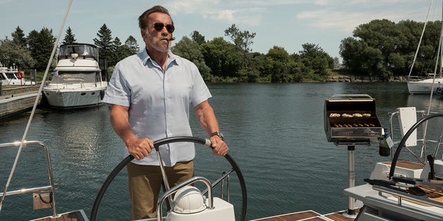 Arnold Schwarzenegger is seen smoking a cigar while driving a boat in a photo from "Fubar."