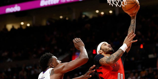 Gary Payton II (00) of the Portland Trail Blazers shoots against Thomas Bryant of the Los Angeles Lakers during the third quarter at Moda Center Jan. 22, 2023, in Portland, Ore.