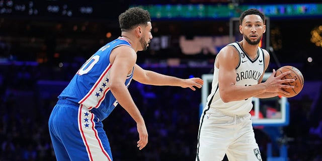 Brooklyn Nets' Ben Simmons, right, controls the ball against Philadelphia 76ers' Georges Niang at the Wells Fargo Center on November 22, 2022 in Philadelphia.