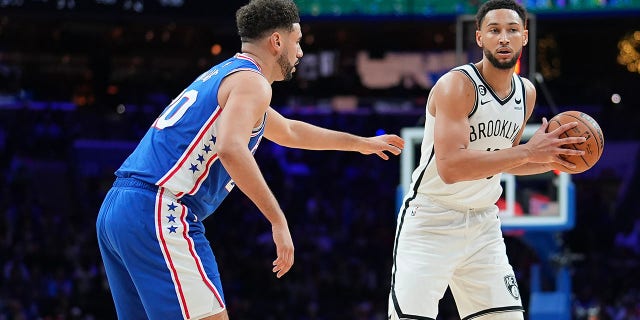 Brooklyn Nets' Ben Simmons, right, controls the ball against Philadelphia 76ers' Georges Niang at the Wells Fargo Center on November 22, 2022 in Philadelphia.