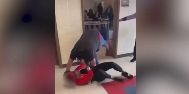 A student is seen pulling Heritage High School teacher Tiwana Turner to the ground during a fight.