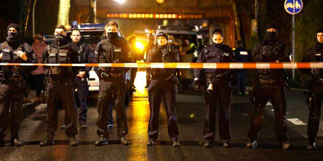 Police officers stand at a barrier near the train accident site in Recklinghausen, Germany, on Feb. 2, 2023. One child was killed, and another was seriously injured in the accident.