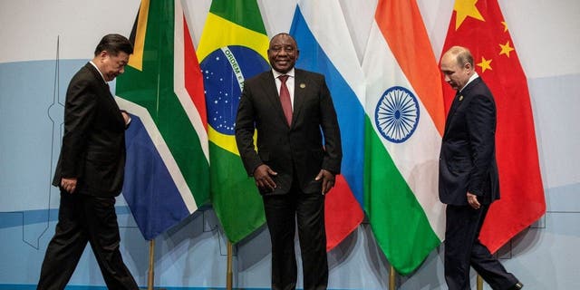 China's President Xi Jinping, South Africa's President Cyril Ramaphosa and Russia's President Vladimir Putin arrive to pose for a group picture during the 10th BRICS (acronym for the grouping of the world's leading emerging economies, namely Brazil, Russia, India, China and South Africa) summit on July 26, 2018.