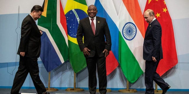 China's President Xi Jinping, South Africa's President Cyril Ramaphosa and Russia's President Vladimir Putin arrive to pose for a group picture during the 10th BRICS (acronym for the grouping of the world's leading emerging economies, namely Brazil, Russia, India, China and South Africa) summit on July 26, 2018.