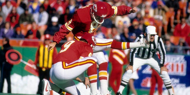 Kansas City Chiefs kicker Nick Lowery #8 kicks a field goal with kicker Bryan Barker #9 holding him during a circa 1993 NFL football game at Arrowhead Stadium in Kansas City, Missouri.  Lowery played for the Chiefs from 1980 to 1993.