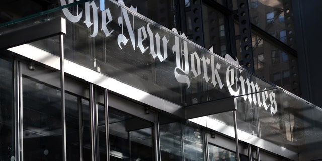 Le logo d'entreprise du New York Times est suspendu au-dessus de la porte d'entrée de son siège social le 23 octobre 2018 à New York.