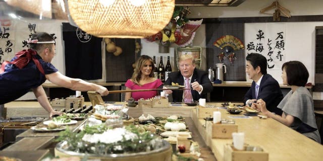 Former President Trump is served a baked potato with butter while sitting at a counter with first lady Melania Trump, Japanese Prime Minister Shinzo Abe and Abe's wife Akie Abe. The pair were photographed often during Trump's multiple trips to the island nation.
