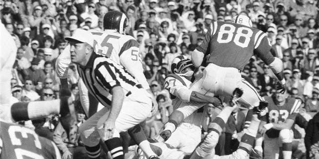 Irv Cross of the Rams tackles the Baltimore Colts' John Mackey at Los Angeles Memorial Coliseum.