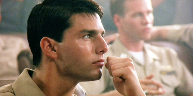 Tom Cruise arsenic Lt. Pete "Maverick" Mitchell. In background, Val Kilmer arsenic Lt. Tom "Iceman" Kazansky. Initial theatrical merchandise May 16, 1986.
