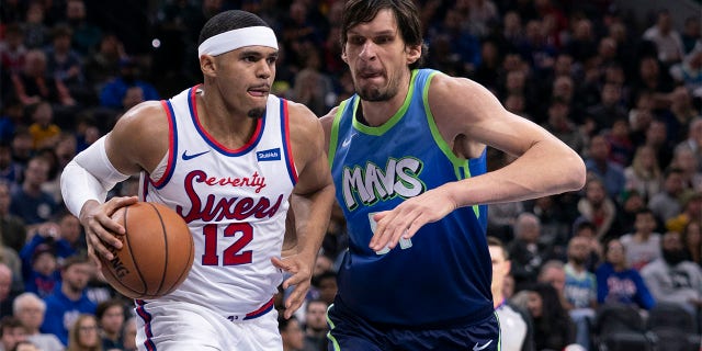 Tobias Harris (12) de los Philadelphia 76ers regatea el balón contra Boban Marjanovic (51) de los Dallas Mavericks en el Wells Fargo Center el 20 de diciembre de 2019 en Filadelfia.