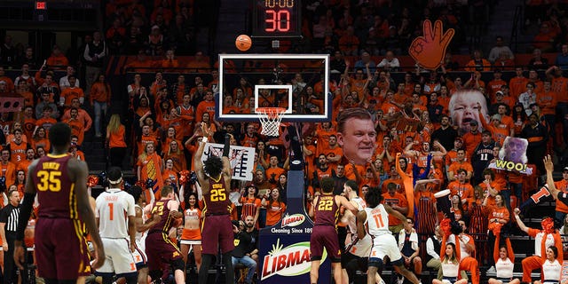 Minnesota Golden Gophers center Daniel Oturu, #25, shoots a free throw with the Illinois Orange Crush student section with signs behind the basket during a college basketball game between the Minnesota Golden Gophers and the Illinois Fighting Illini on January 30, 2020 at State Farm.  Center in Champaign, Illinois.