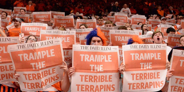 La sección de estudiantes de Orange Krush leyó el periódico The Daily Illini mientras se presenta al equipo visitante antes del comienzo del partido de baloncesto universitario Big Ten Conference entre Maryland Terrapins e Illinois Fighting Illini el 7 de febrero de 2020, en el State Farm Center en Champaign, Illinois. . 