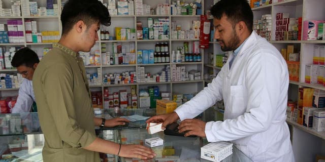 A customer buys medicines at a pharmacy in Kabul, Afghanistan.  29, 2020.