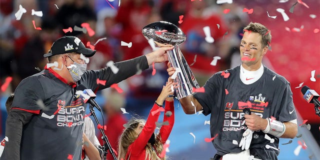 Super Bowl MVP Tom Brady of the Buccaneers accepts the Lombardi Trophy from general manager Jason Licht after Super Bowl LV between the Kansas City Chiefs and the Tampa Bay Buccaneers on February 7, 2021, at the Raymond James Stadium, in Tampa, Florida. 