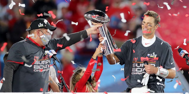 Super Bowl MVP Tom Brady of the Buccaneers accepts the Lombardi Trophy from general manager Jason Licht after Super Bowl LV between the Kansas City Chiefs and the Tampa Bay Buccaneers Feb. 7, 2021, at Raymond James Stadium, in Tampa, Fla. 