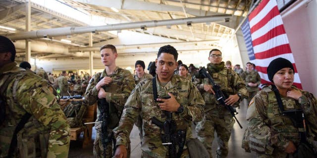 Soldiers with the 82nd Airborne division listen to instructions before deploying to Poland on Feb. 14, 2022 at Fort Bragg, Fayetteville, North Carolina ahead of Russia's invasion of Ukraine.