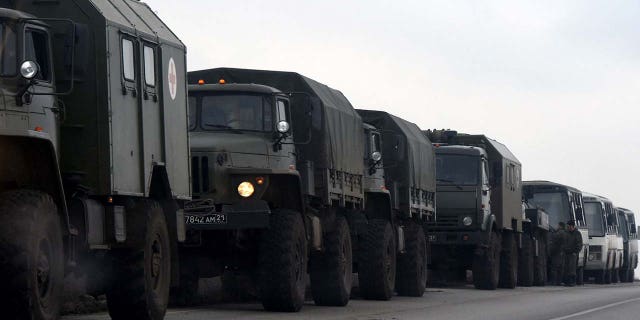 A line of military vehicles along a road.