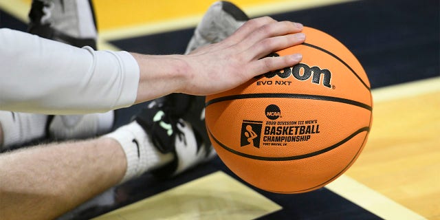 A championship logo is seen on a basketball as a player warms up for the Division III National Championship basketball game between the Randolph-Macon Yellow Jackets and the Elmhurst Bluejays on March 19, 2022, at the Allen County War Memorial Coliseum in Fort Wayne, Indiana.
