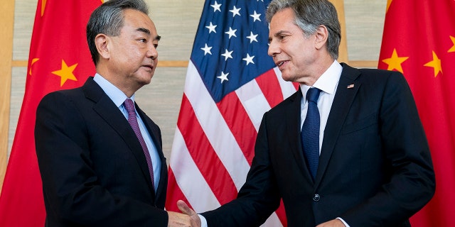 Wang Yi and Antony Blinken shake hands