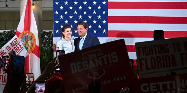 Casey DeSantis stands next to her husband Florida Governor Ron DeSantis as he campaigns for re-election during a "Unite and Win" rally on the eve of the US midterm elections, at Hialeah Park Clubhouse, in Hialeah, Florida, on November 7, 2022.