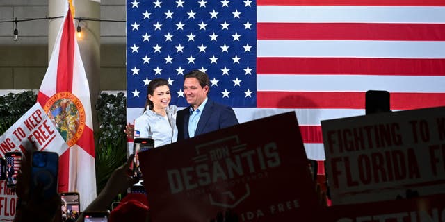 Casey DeSantis stands next to her husband Florida Governor Ron DeSantis as he campaigns for re-election during a "Unite and Win" rally on the eve of the US midterm elections, at Hialeah Park Clubhouse, in Hialeah, Florida, on November 7, 2022.