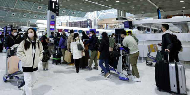 Travelers guidelines successful statement adjacent check-in counters successful a departure hallway astatine Narita International Airport successful Narita, Japan, connected Dec. 30, 2022. Japan is easing COVID-19 separator measures for  visitors from China. 