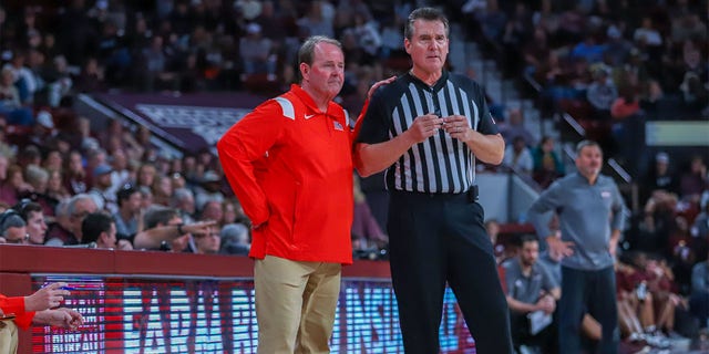 Ole Miss Rebels head coach Kermit Davis, left, talks with referee Doug Shows during the game between the Mississippi State Bulldogs and the Ole Miss Rebels on Jan. 7, 2023 at Humphrey Coliseum in Starkville, Mississippi.