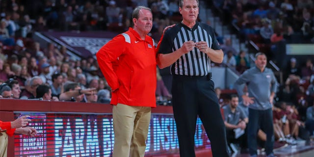 El entrenador en jefe de Ole Miss Rebels, Kermit Davis, habla con el árbitro Doug Shows durante el juego entre Mississippi State Bulldogs y Ole Miss Rebels el 7 de enero de 2023 en Humphrey Coliseum en Starkville, MS.