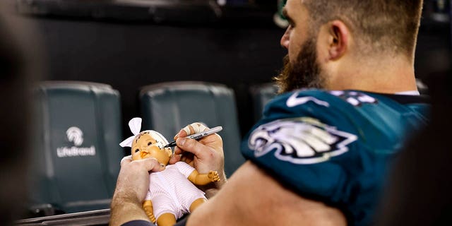 Jason Kelce of the Philadelphia Eagles signs a doll for a fan after an NFL divisional round playoff game against the New York Giants at Lincoln Financial Field Jan. 21, 2023, in Philadelphia. 