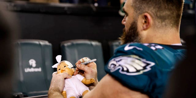 Jason Kelce of the Philadelphia Eagles signs a doll for a fan after an NFL divisional round playoff game against the New York Giants at Lincoln Financial Field Jan. 21, 2023, in Philadelphia. 