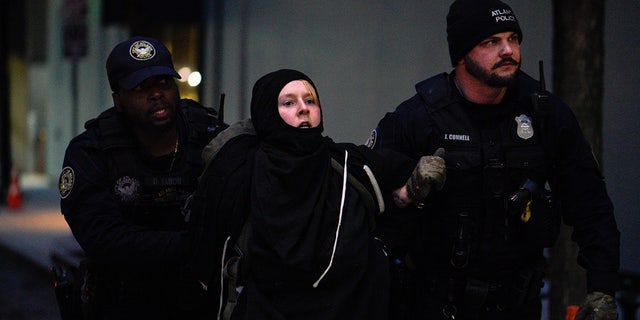 Police arrest a demonstrator during a "Stop Cop City" protest in Atlanta, Georgia, on Jan. 21, 2023, after a police vehicle was set ablaze.