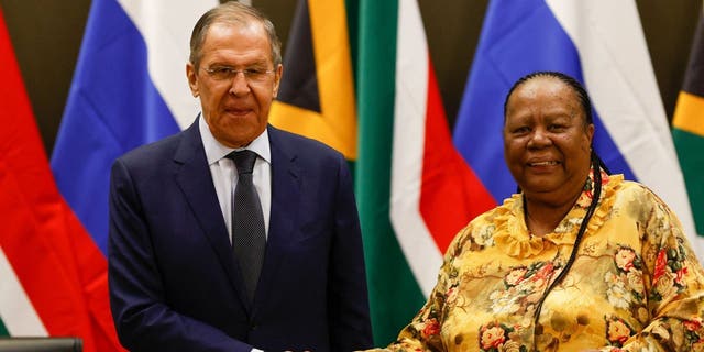Menteri Luar Negeri Rusia Sergei Lavrov (kiri) berjabat tangan dengan Menteri Hubungan Internasional dan Kerjasama Afrika Selatan Naledi Pandor (kanan) selama konferensi pers setelah pertemuan mereka di Gedung OR Tambo di Pretoria pada 23 Januari 2023. 
